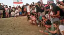Sejumlah pengunjung melihat pelepasan tukik di pantai al-Mansouri dekat kota Tyre, Lebanon selatan (31/7/2019). Pelepasan ratusan anak penyu ini bagian pelestarian hewan yang terancam punah. (AFP Photo/Mahmoud Zayyat)