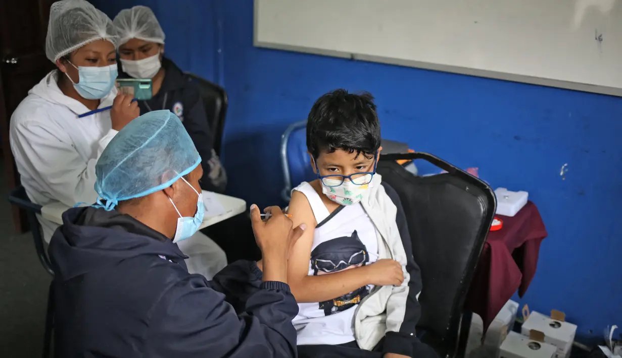 Seorang anak menerima dosis vaksin covid-19 Sinopharm di La Paz, Bolivia, Kamis (9/12/2021). Presiden Bolivia Luis Arce mengizinkan vaksinasi anak berusia antara 5 hingga 11 tahun untuk menekan laju peningkatan infeksi COVID-19 di negara itu. (LUIS GANDARILLAS / AFP)