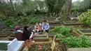 Ziarah makam merupakan tradisi dilakukan sebagian besar masyarakat Indonesia untuk mendoakan keluarga yang telah wafat dan membersihkan pusara. Tampak dalam foto, warga saat berziarah di makam keluarganya di Tempat Pemakaman Umum (TPU) Dreded, Bogor, Jawa Barat, Minggu (15/2/2026). (merdeka.com/Arie Basuki)