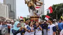 Simpatisan Partai NasDem berselfie saat pawai ogoh-ogoh dalam aksi Kita Indonesia di kawasan Bundaran HI, Jakarta, Minggu (04/12). Aksi tersebut diisi dengan parade budaya Indonesia dan orasi tokoh politik nasoional Indonesia. (Liputan6.com/Fery Pradolo)