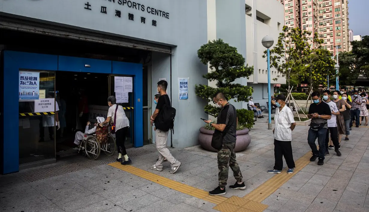Sejumlah orang menunggu dalam antrean di pusat pengujian virus corona COVID-19, Hong Kong, Selasa (1/9/2020). Hong Kong mulai melakukan tes massal virus corona COVID-19. (ISAAC LAWRENCE/AFP)