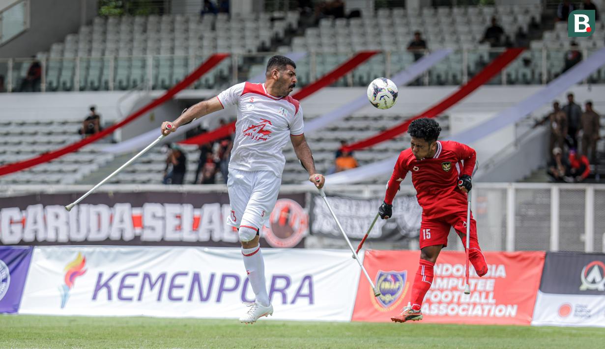 Pemain Timnas Amputasi Indonesia, Sahata Sianturi (kanan) berduel udara dengan pemain Iran dalam laga Grup A Kualifikasi Piala Dunia Amputasi 2026 di Stadion Madya, Senayan, Jakarta, Kamis (13/11/2025). (Bola.com/Bagaskara Lazuardi)