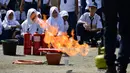Para siswa menyaksikan petugas pemadam kebakaran memeragakan cara memadamkan api, Banda Aceh, Senin (11/11/2019). Sebanyak 439 pelajar mendapat pembekalan cara pencegahan pemadaman api akibat kebakaran dari petugas Dinas Pemadam Kebakaran dan Penyelamatan Kota Banda Aceh. (CHAIDEER MAHYUDDIN/AFP)