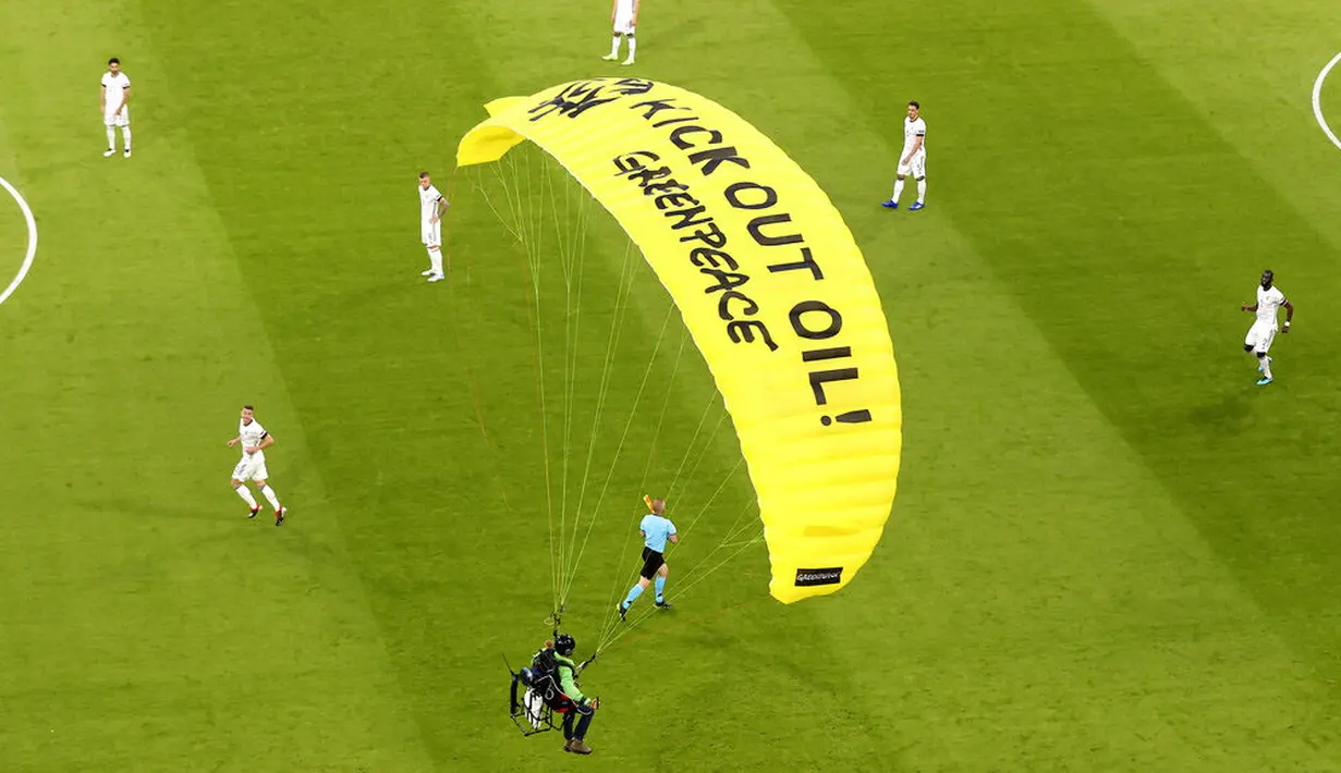 Aktivis Greenpeace menggunakan paraglider mendarat di lapangan sebelum pertandingan Jerman melawan Prancis dalam penyisihan Grup F Piala Eropa di Allianz Arena, Munich, (15/6/2021). (AP/ctivist Alexander Hassenstein, Pool)