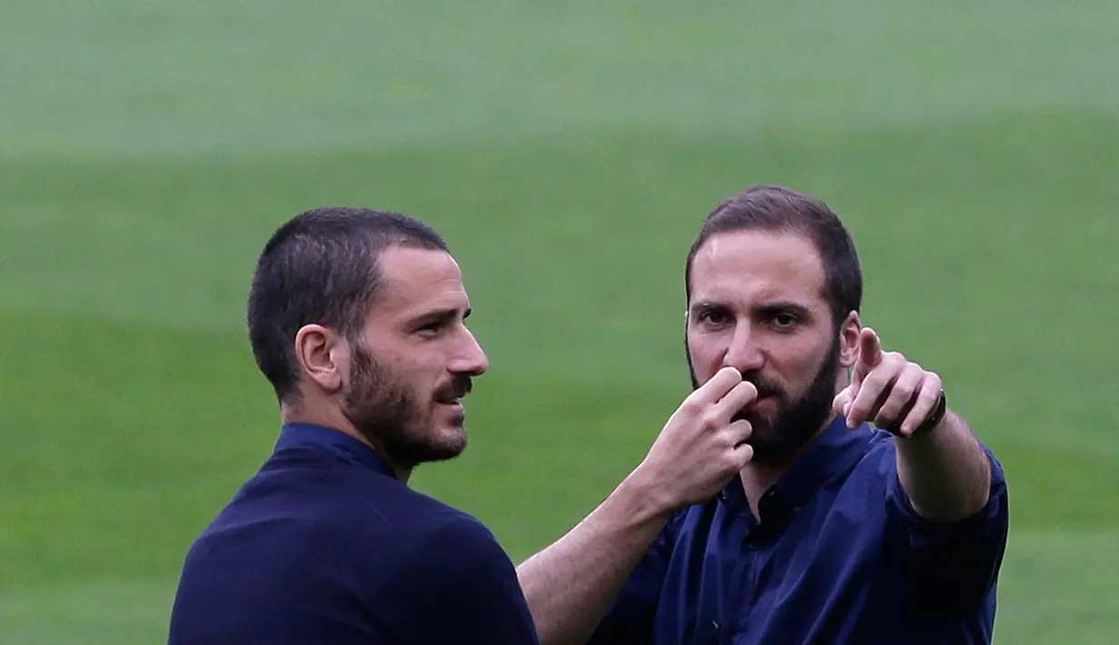 Penyerang Juventus, Gonzalo Higuain berbincang dengan bek Leonardo Bonucci di stadion Camp Nou, Barcelona, Spanyol, (18/4). Juventus akan bertanding melawan Barcelona di leg kedua perempat final Liga Champions. (AP Photo/Manu Fernandez)