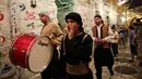 Kelompok pemuda Palestina memukul gendang ketika membangunkan kaum muslim untuk sahur di Kota Tua Yerusalem, Selasa (5/6). Dalam tradisi Musaharati ini, biasanya mereka memakai alat musik sambil menyanyikan lagu-lagu religius. (AP/Mahmoud Illean)
