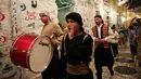 Kelompok pemuda Palestina memukul gendang ketika membangunkan kaum muslim untuk sahur di Kota Tua Yerusalem, Selasa (5/6). Dalam tradisi Musaharati ini, biasanya mereka memakai alat musik sambil menyanyikan lagu-lagu religius. (AP/Mahmoud Illean)