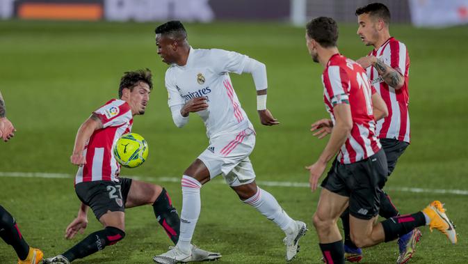 Vinicius Junior berebut bola dengan Unai Vencedor pada pertandingan Liga Spanyol antara Real Madrid dan Athletic Club Bilbao di stadion Alfredo Di Stefano di Madrid, Spanyol, Selasa, 15 Desember, 2020. (Foto AP / Bernat Armangue)