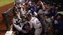 Pemain Los Angeles Dodgers, Cody Bellinger dibantu rekan-rekannya saat terjatuh di tempat istirahat pada pertandingan kelima dalam game 3 dari Divisi Liga Nasional baseball di Phoenix (9/10). (Christian Petersen / Getty Images / AFP)