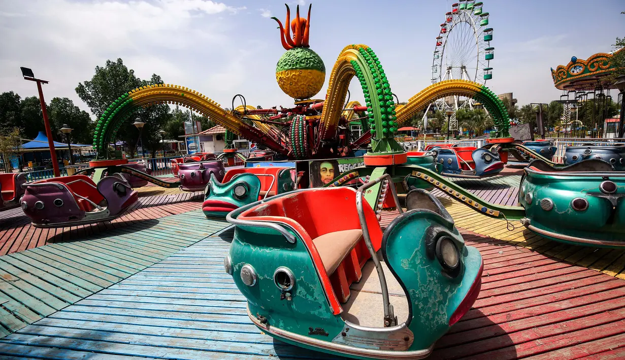 Foto yang diambil 24 Mei 2020 pada hari pertama Idul Fitri menunjukkan pemandangan atraksi permainan anak-anak yang sepi di sebuah taman di ibu kota Irak, Baghdad yang ditutup karena pandemi virus corona COVID-19. (Photo by AHMAD AL-RUBAYE / AFP)