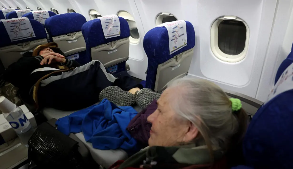 Pengungsi Yahudi Ukraina dan imigran baru dengan kesehatan buruk yang melarikan diri dari perang di negara mereka menunggu untuk turun dari pesawat setibanya di Bandara Ben Gurion, Tel Aviv, Israel, 22 Desember 2022. Sebanyak 100 orang Yahudi Ukraina tiba di Israel, termasuk beberapa penumpang yang terbaring di tempat tidur dan dalam kondisi sakit. (GIL COHEN-MAGEN/AFP)