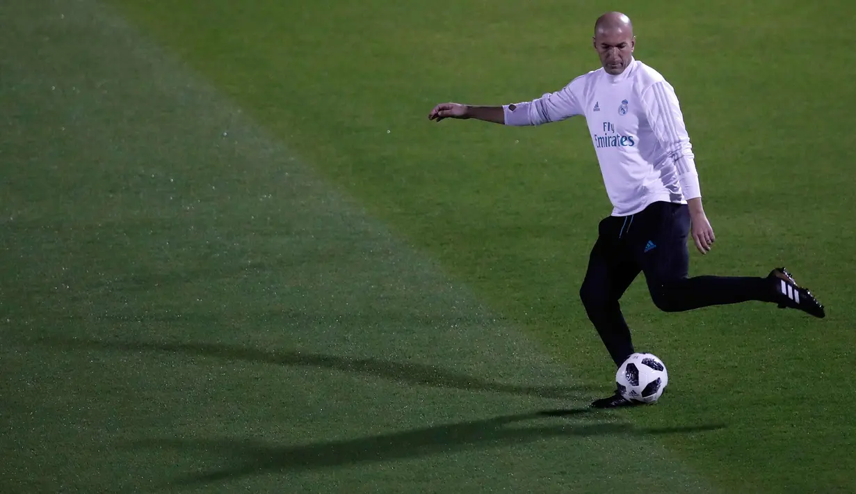 Pelatih Real Madrid, Zinedine Zidane berusaha menendang bola saat mengikuti sesi latihan di Abu Dhabi, Uni Emirat Arab, (14/12). Real Madrid akan bertanding melawan klub Brasil Gremio di pertandingan final Piala Dunia Klub 2017. (AP Photo / Hassan Ammar)