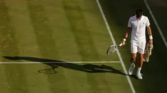 Petenis Serbia, Novak Djokovic berjalan di lapangan pada babak perempatfinal Wimbledon 2017 saat bertemu petenis Ceko, Tomas Berdych, Rabu (12/7). Djokovic memutuskan mundur setelah mengalami cedera siku saat menjalani pertandingan. (AP/Alastair Grant)