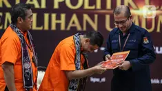 Ketua Umum Partai Buruh Said Iqbal (tengah) menyerahkan berkas pendaftaran sebagai partai politik calon peserta Pemilu 2024 kepada Ketua Komisi Pemilihan Umum (KPU) Hasyim Asy'ari (kanan) di Kantor KPU, Jakarta, Jumat (12/8/2022). Partai Buruh mendaftarkan diri sebagai partai ke-25 calon peserta Pemilu 2024. (Liputan6.com/Johan Tallo)