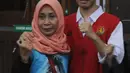 Dede Luthfi Alfiandi, pembawa bendera Merah Putih saat aksi siswa SMK September lalu, bersama ibunya di Pengadilan Negeri Jakarta Pusat, Kamis (12/12/2019). Luthfi didakwa melanggar Pasal 212 KUHP juncto Pasal 214 KUHP atau Pasal 217 ayat 1 KUHP atau 218 KUHP. (Liputan6.com/Helmi Fithriansyah)