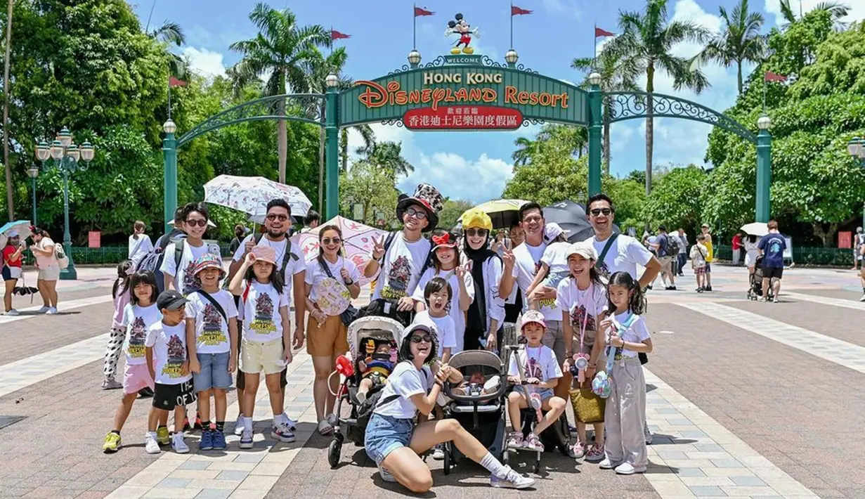 Tampak Ananda Omesh dan para anggota Podkesmas tengah berada di Disneyland Hong Kong. Sebelum masuk ke area wahana permainan, mereka berfoto bersama di depan pintu masuk. Suasana pun ramai dan kompak karena para istri dan anak mengenakan kaus putih yang sama. (Liputan6.com/IG/@podkesmas)