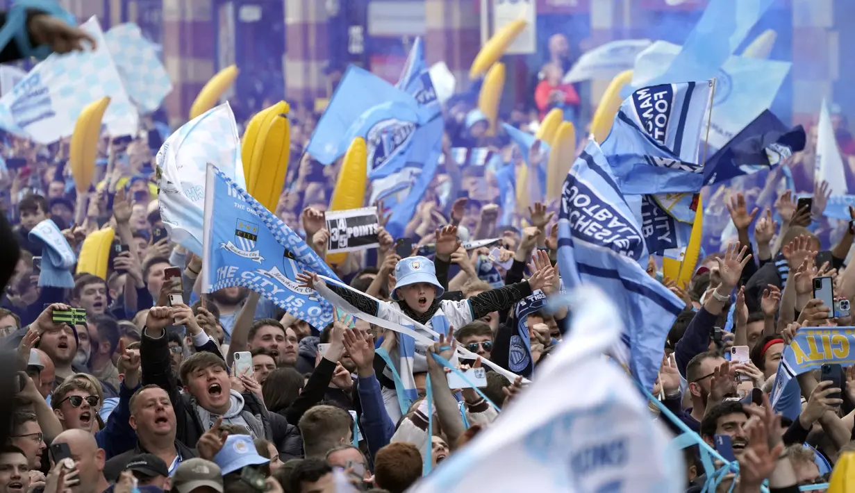 Fans bersorak saat menyaksikan parade kemenangan Manchester City dalam Liga Inggris di Manchester, Inggris, 23 Mei 2022. (AP Photo/Jon Super)