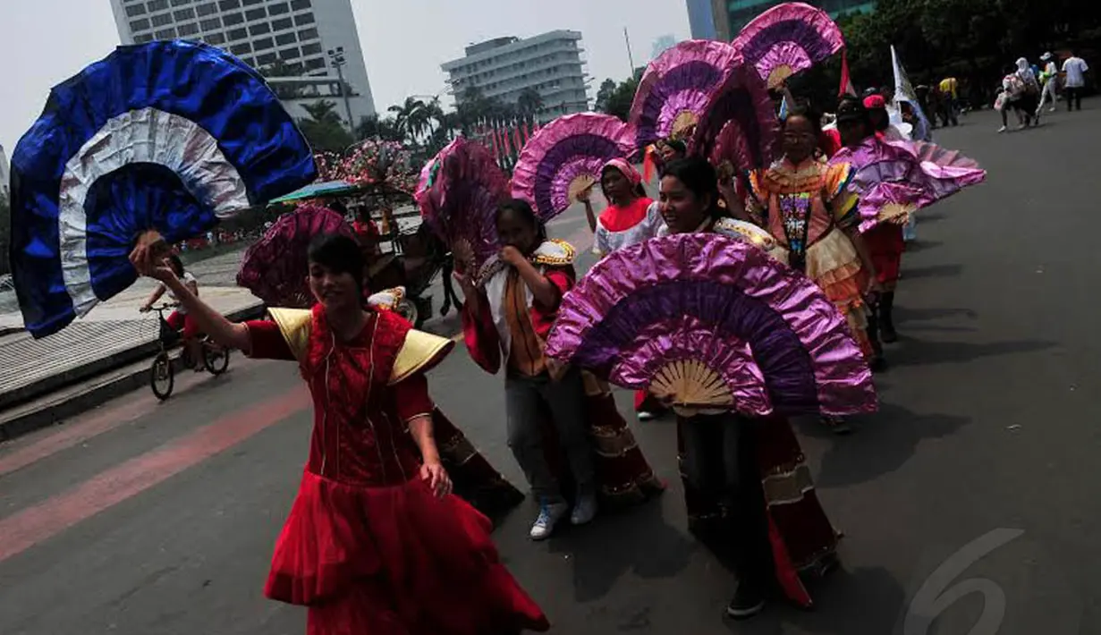 Ratusan anak dan remaja Indonesia berkeliling Bundaran HI dengan ragam kostum dan gaun yang unik, Minggu (02/11/14) (Liputan6.com/Johan Tallo)