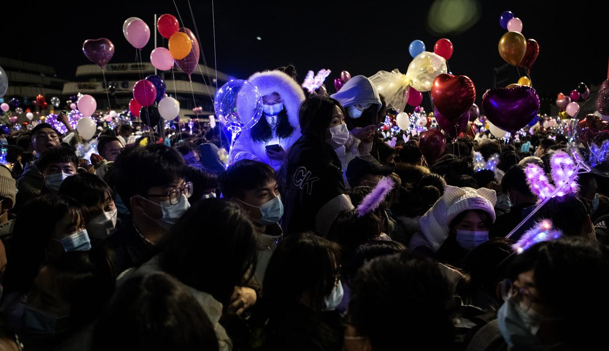 Orang-orang menghadiri  hitung mundur di Wuhan, provinsi Hubei tengah China, pada 31 Desember 2020, meskipun ada pembatasan Covid-19 dan kembang api Tahun Baru dibatalkan. (AFP/Noel Celis)