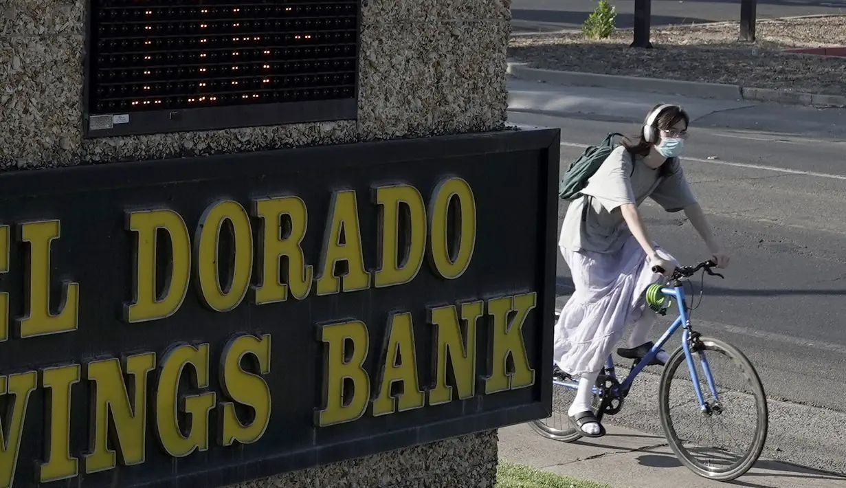 Seorang pengendara sepeda melewati tanda bank yang menampilkan suhu 116 derajat di Sacramento, California, Senin, 5 September 2022. Layanan Cuaca Nasional melaporkan suhu di atas 112 tanda di daerah Sacramento. (AP Photo/Rich Pedroncelli)