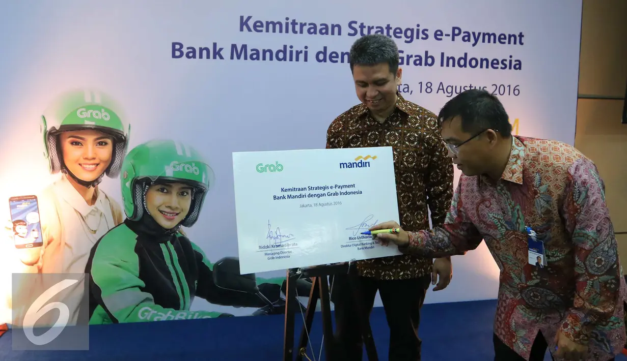 Direktur Digital Banking and Technology Bank Mandiri Rico Usthavia Frans (kanan) menandatangi perjanjian kerja sama antara Bank Mandiri dengan Grab Indonesia di Plaza Bank Mandiri, Jakarta, Kamis (18/8). (Liputan6.com/Angga Yuniar)