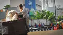 Petugas merapikan sampah agar tidak tercecer di kawasan Kebon Jeruk, Jakarta, Selasa (8/3/2016). Mereka menunggu truk yang akan mengangkut sampah yang mereka bawa. (Liputan6.com/Faisal R Syam)