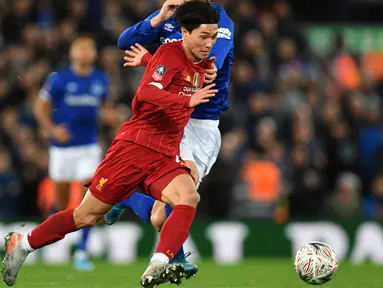 Gelandang Liverpool, Takumi Minamino menggiring bola dari kawalan pemain Everton, Gylfi Sigurdsson pada pertandingan babak ketiga Piala FA di Anfield, Minggu (5/1/2020). Pemain Jepang menjalani debut bersama Liverpool dengan menjadi starter dipertandingan tersebut. (AFP/Paul Ellis)