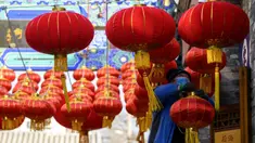 Seorang pekerja memasang lentera tradisional Tiongkok di sepanjang gang menjelang Tahun Baru Imlek di Beijing, China, 2 Februari 2021. Imlek tahun ini jatuh pada tanggal 12 Februari 2021. (NOEL CELIS/AFP)