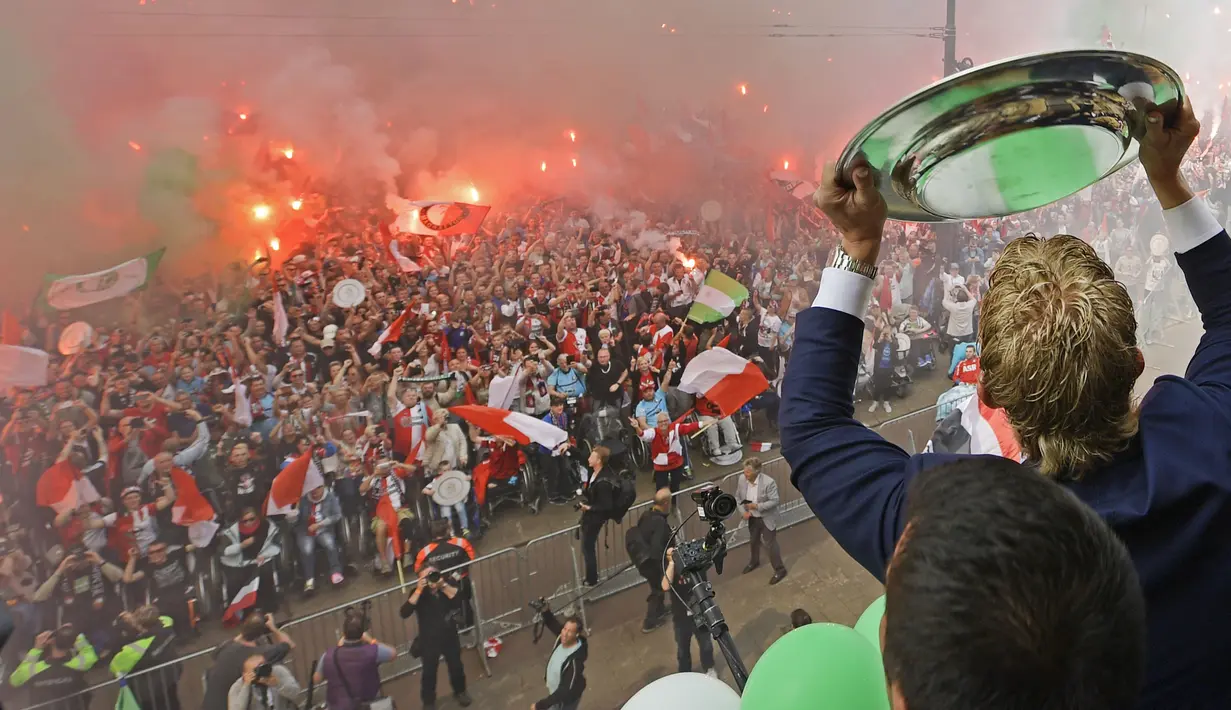Pemain dan suporter bersorak merayakan pesta juara Liga Belanda di Rotterdam (15/5). Bagi Feyenoord, ini adalah gelar liga pertama dalam kurun waktu 18 tahun terakhir atau yang ke-15 sepanjang sejarah klub. (AFP Photo/ANP/Olaf Kraak/Netherlands Out)