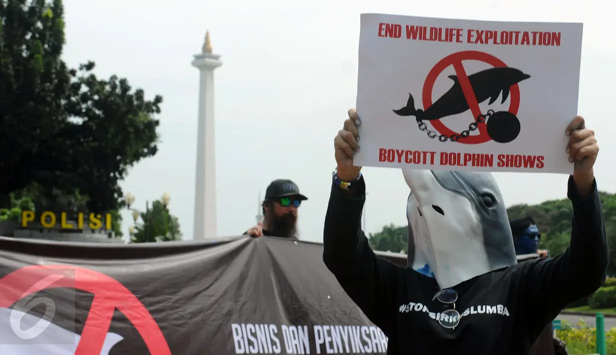 Aktivis JAAN membentangkan tulisan menolak eksploitasi hewan lumba-lumba di Jakarta, Senin (31/10). Mereka menilai pentas satwa lumba-lumba tidak menyampaikan pesan edukasi dan tidak menghargai . (Liputan6.com/Helmi Fithriansyah)