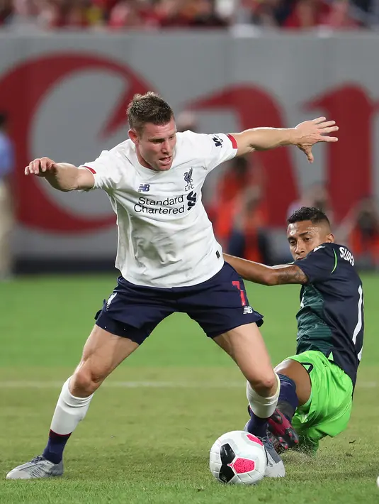 Gelandang Liverpool, James Milner berebut bola dengan pemain Sporting CP selama pertandingan uji coba di Stadion Yankee, Amerika Serikat, Kamis (25/7/2019). Liverpool ditahan imbang Sporting dengan skor 2-2. (AFP Photo/Al Bello)