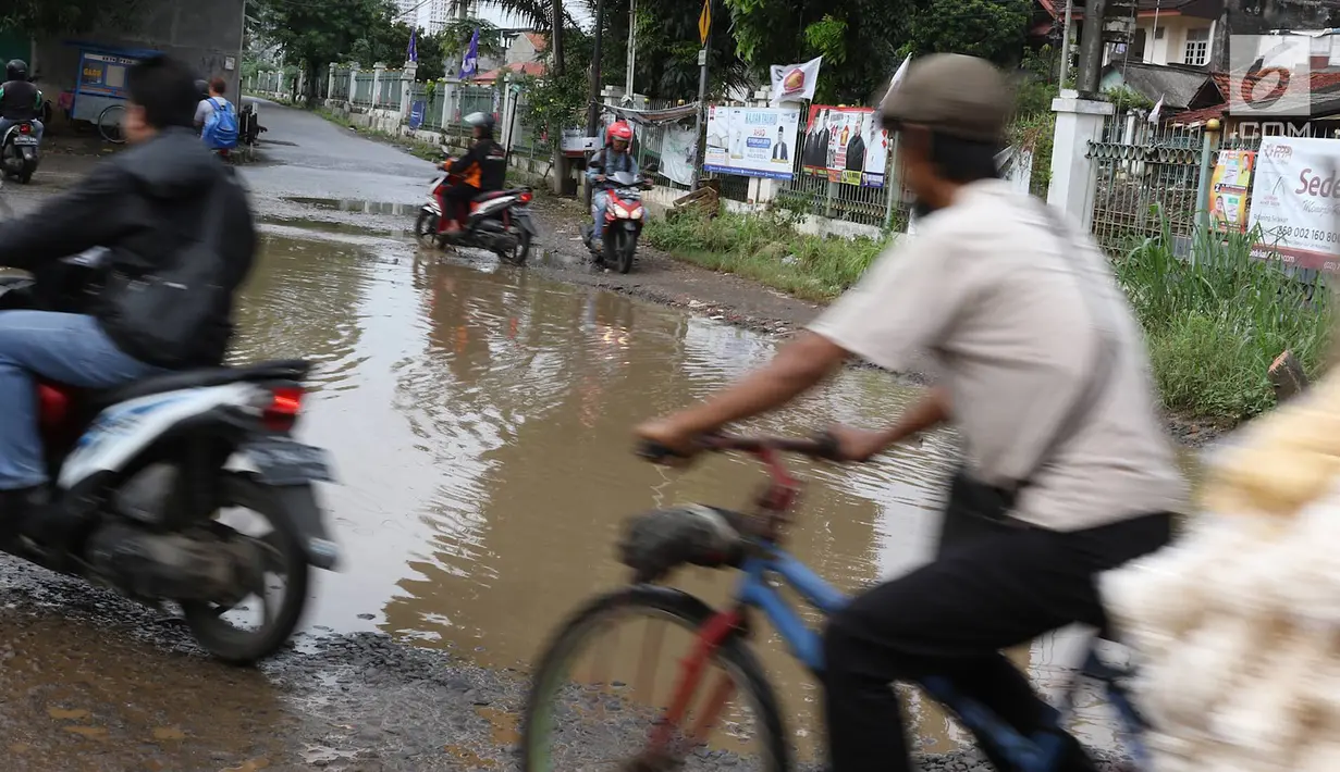 Kendaraan menghindari kubangan pada jalan yang rusak di Jalan Pertamina, Kemiri Muka, Depok, Jawa Barat, Selasa (5/3). Kondisi tersebut mengganggu aktivitas warga serta pengguna jalan. (Liputan6.com/Immanuel Antonius)
