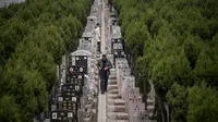 Seorang pria berjalan diantara batu nisan saat festival Qingming di sebuah pemakaman di Shanghai (6/6). Untuk orang Tionghoa, perayaan ini dilakukan untuk mengingat dan menghormati nenek moyang. (AFP/Johannes Eisele)