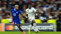 Pemain Real Madrid, Vinicius Junior (kanan) berebut bola dengan pemain Chelsea, Reece James pada laga leg pertama perempat final Liga Champions 2022/2023 di Santiago Bernabeu, Madrid, Kamis (13/04/2023) WIB. Los Blancos menang dengan skor 2-0. (AP Photo/Jose Breton)