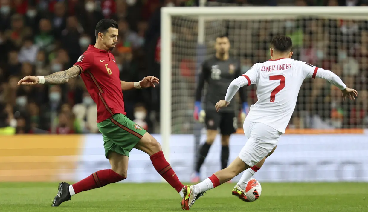 Bek Portugal, Jose Fonte (kiri) berebut bola dengan gelandang Turki, Cengiz Under selama pertandingan playoff Piala Dunia 2022 di stadion Dragao di Porto, Portugal, Jumat (25/3/2022). Portugal menang atas Turki 3-1. (AP Photo/Luis Vieira)
