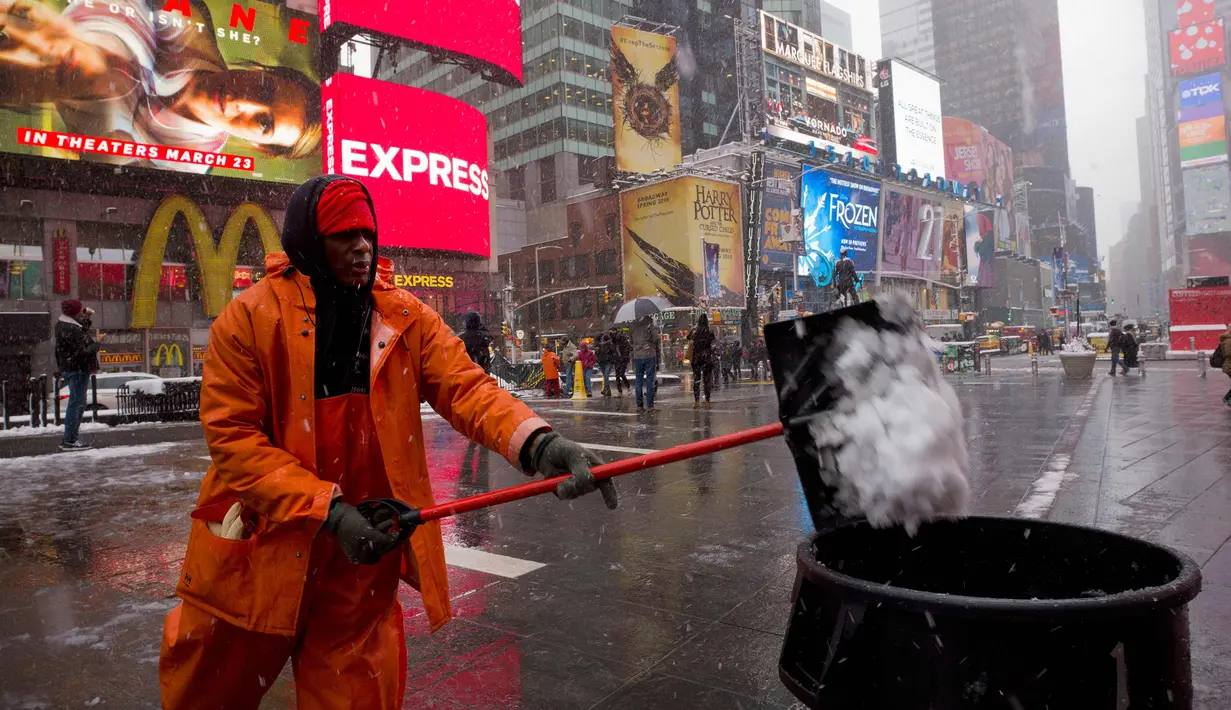 Michael Vante membersihkan salju di New York Times Square, (21/3). Badai salju yang melanda sebagian Amerika Serikat telah membawa salju dan angin kencang. (AP Photo / Mary Altaffer)