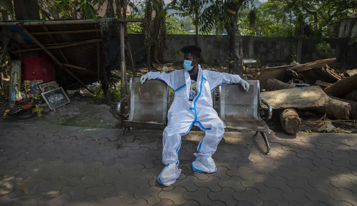 Seorang petugas kesehatan yang kelelahan beristirahat setelah membawa jenazah seseorang untuk dikremasi di Gauhati, India, Selasa (27/4/2021). Kasus virus corona COVID-19 di India melonjak lebih cepat dari tempat lain di dunia. (AP Photo/Anupam Nath)