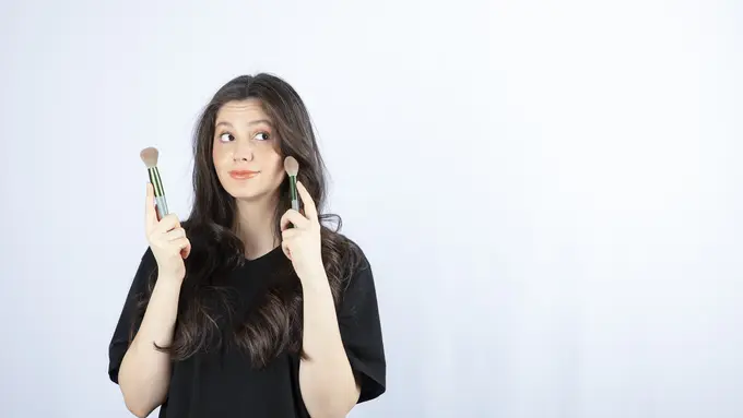 Seorang perempuan sedang memegang dua buah brush di tangannya (Foto Dok: Freepik/azerbaijan_stockers)