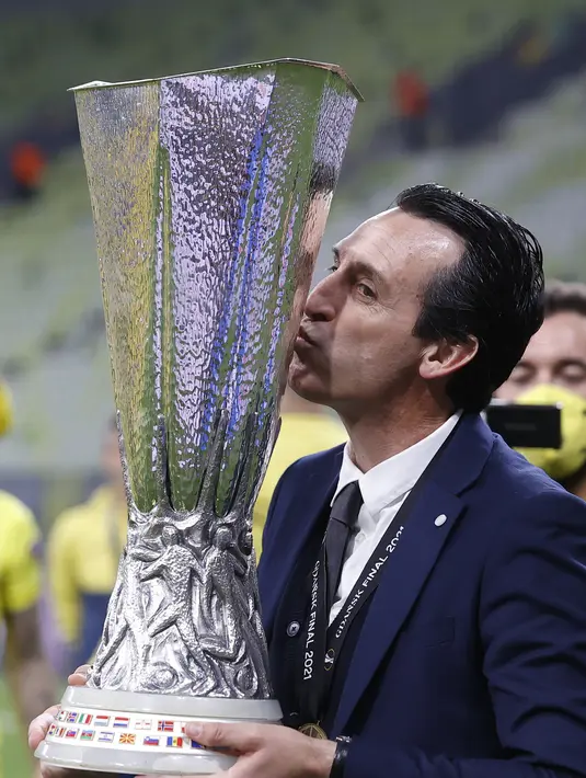 Pelatih Villareal, Unai Emery mencium trofi saat merayakan timnya memenangkan pertandingan melawan Manchester United pada final Piala Europa di Gdansk, Polandia, Kamis (27/5/2021).  Villareal berhak ke Liga Champions musim depan lewat jalur ini, meski di LaLiga finis ketujuh. (Kacper Pempel, Pool vi