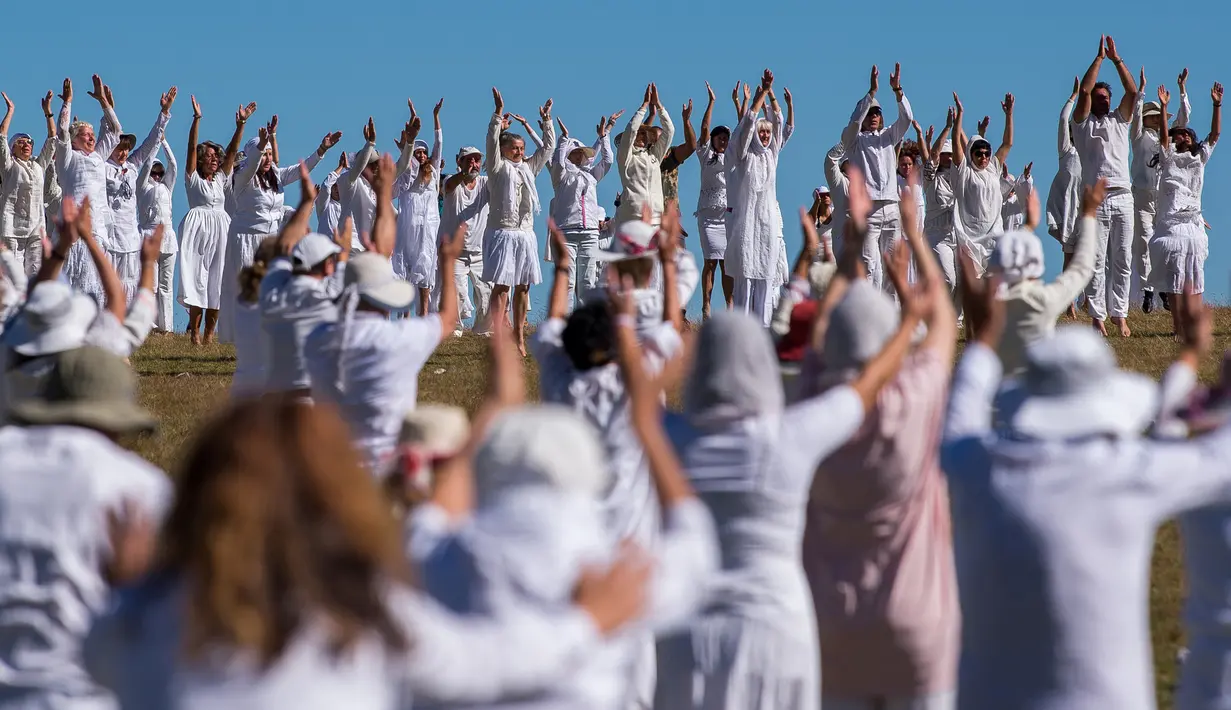 Anggota gerakan keagamaan internasional White Brotherhood menari di puncak Gunung Rila, Bulgaria, Senin (19/8/2019). Penari berpakaian serba putih menari di ketinggian 2.100 meter dan melakukan tarian meditasi khusus yang dikenal sebagai "paneurhythmy". (NIKOLAY DOYCHINOV/AFP)