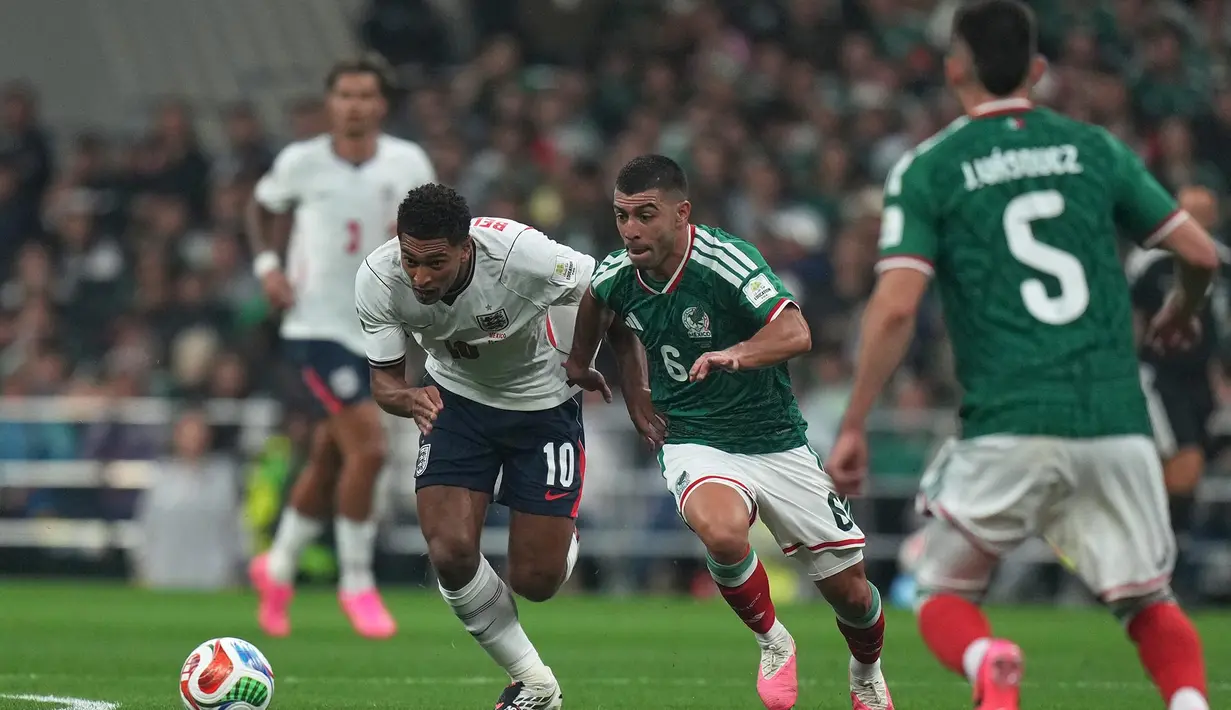 Pemain Meksiko Erik Lira berebut bola dengan pemain Inggris Jude Bellingham selama pertandingan sepak bola babak 16 besar Piala Dunia antara Meksiko dan Inggris di Mexico City, Minggu, 5 Juli 2026. (AP Photo/Silvia Izquierdo)
