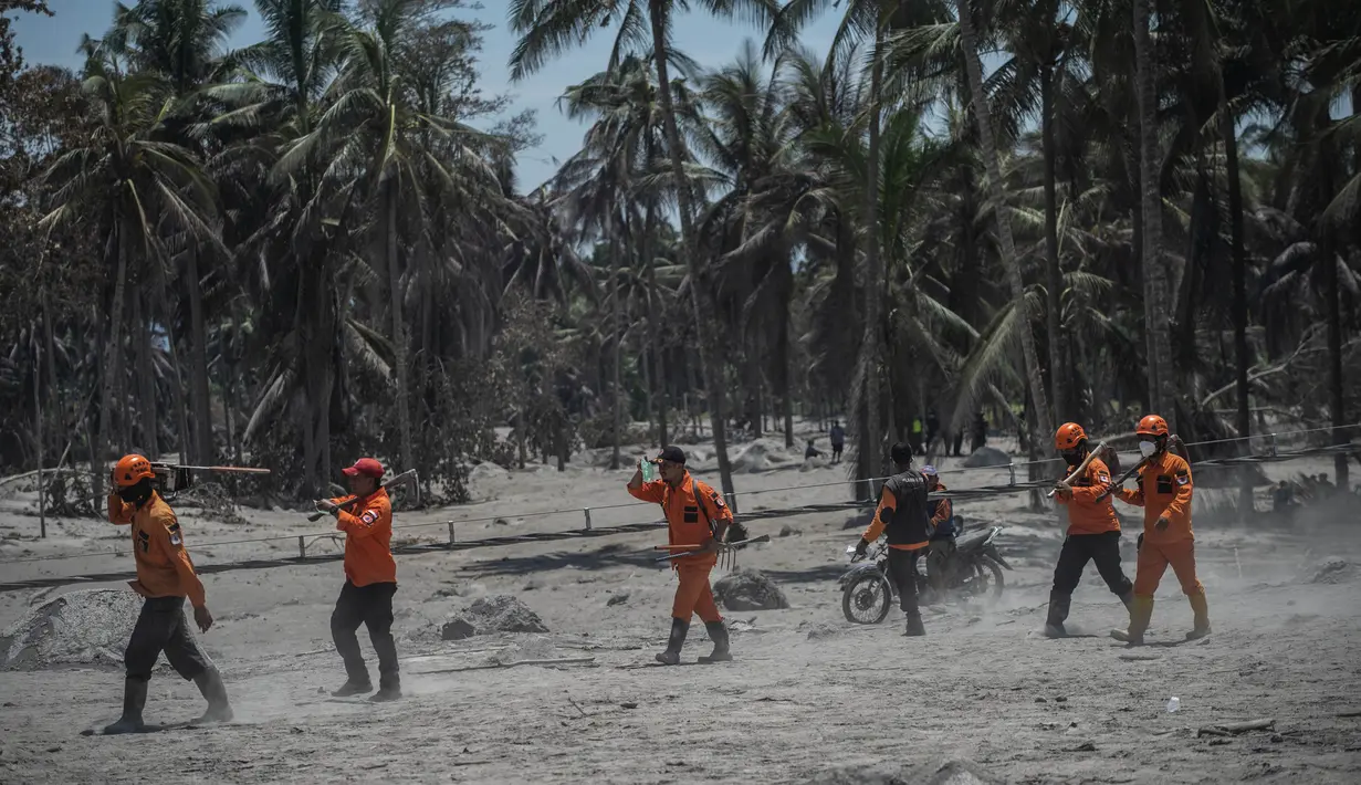 Tim penyelamat tiba untuk mencari korban di rumah yang terkubur abu vulkanik letusan Gunung Semeru di Desa Sumber Wuluh, Lumajang, Jawa Timur, Selasa (7/12/2021). Letusan Gunung Semeru menewaskan sedikitnya 34 orang. (AFP/Juni Kriswanto)