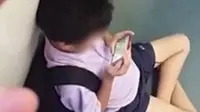 Seorang anak sekolah berseragam dengan cueknya menonton video porno buat kaget penumpang kereta lainnya