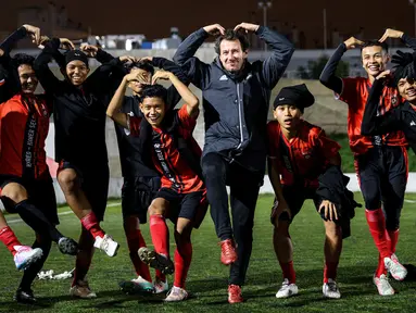 Pemain Korea-Korea Selecao foto bersama dengan pelatih Victoria Clube de Lisboa, Miguel Saragaco, setelah sesi latihan hari keempat, Minggu (24/11/2024). (Bola.com/Bagaskara Lazuardi)