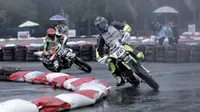 Pebalap muda Indonesia, Diva Ismayana (kiri) mencoba mengejar Natthapat Suksanwatt (kanan)  pada ajang FIM Asia Supermoto 2016 di Kompleks Stadion Kanjuruhan, Malang, Minggu (9/10/2016) (Bola.com/Reza Bachtiar)