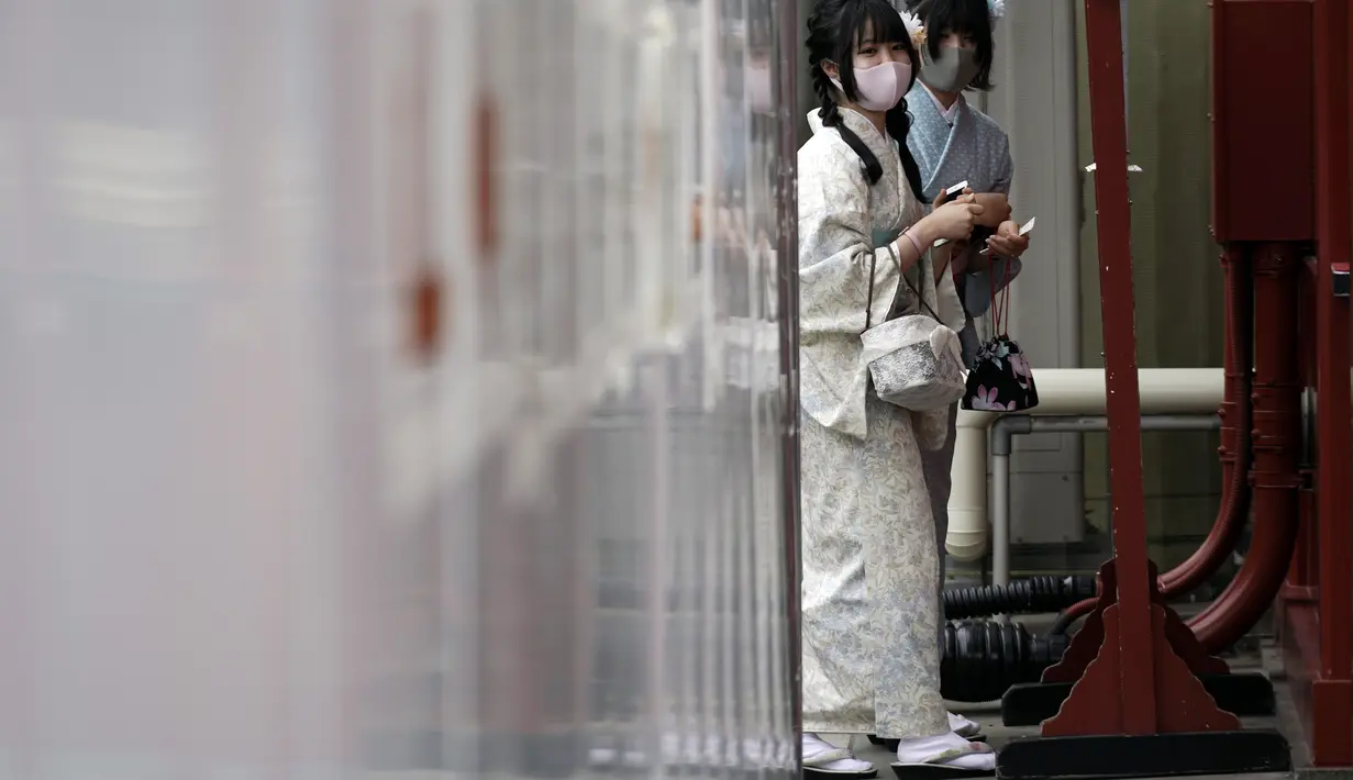 Orang-orang yang mengenakan masker pelindung untuk membantu mencegah penyebaran virus corona berjalan di pusat perbelanjaan di distrik Asakusa di Tokyo, Selasa (29/9/2020). kota Jepang mengonfirmasi lebih dari 200 kasus virus corona pada hari Selasa. (AP Photo/Eugene Hoshiko)