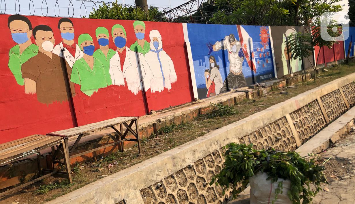 Deretan mural bertema covid-19 di kawasan Bukit Duri, Jakarta, Minggu (30/8/2020). Mural yang dibuat oleh petugas PPSU tersebut bertujuan untuk mengingatkan masyarakat akan bahaya covid-19, sehubungan dengan masih tingginya jumlah kasus positif covid-19 di Jakarta. (Liputan6.com/Immanuel Antonius)