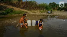 Seorang anak menemani ayahnya mengambil air dari Kali Cihoe di Desa Sukagalih, Jonggol, Bogor, Minggu (8/9/2024). (merdeka.com/Arie Basuki)