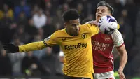 Gelandang Wolverhampton Wanderers, Joao Gomes (kiri) berebut bola dengan gelandang Arsenal, Leandro Trossard pada laga pekan ke-33 Premier League 2023/2024 di Molineux Stadium, Wolverhampton, Sabtu (20/4/2024). (AP Photo/Rui Vieira)