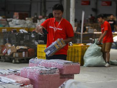 Pekerja menyortir paket yang akan dikirim ke berbagai kota di Mega Hub Lion Parcel, Kota Tangerang, Banten, Rabu (18/12/2024). (Liputan6.com/Angga Yuniar)